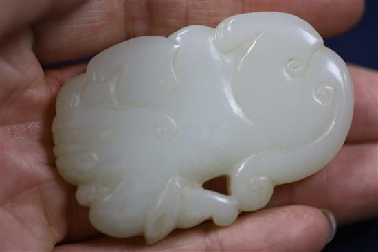 A Chinese white jade lion-dog plaque, 18th century, 6cm, wood stand